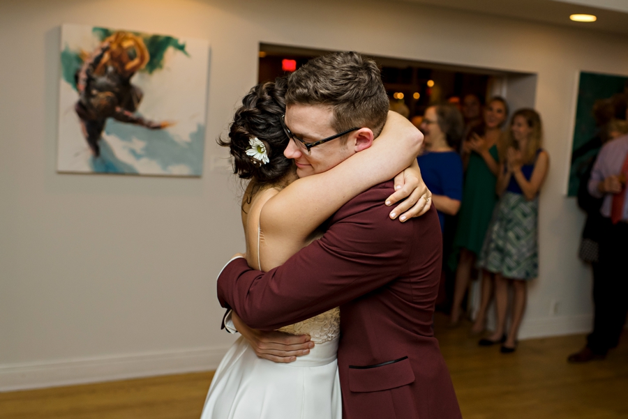 A bride hugs her groom on the dance floor.